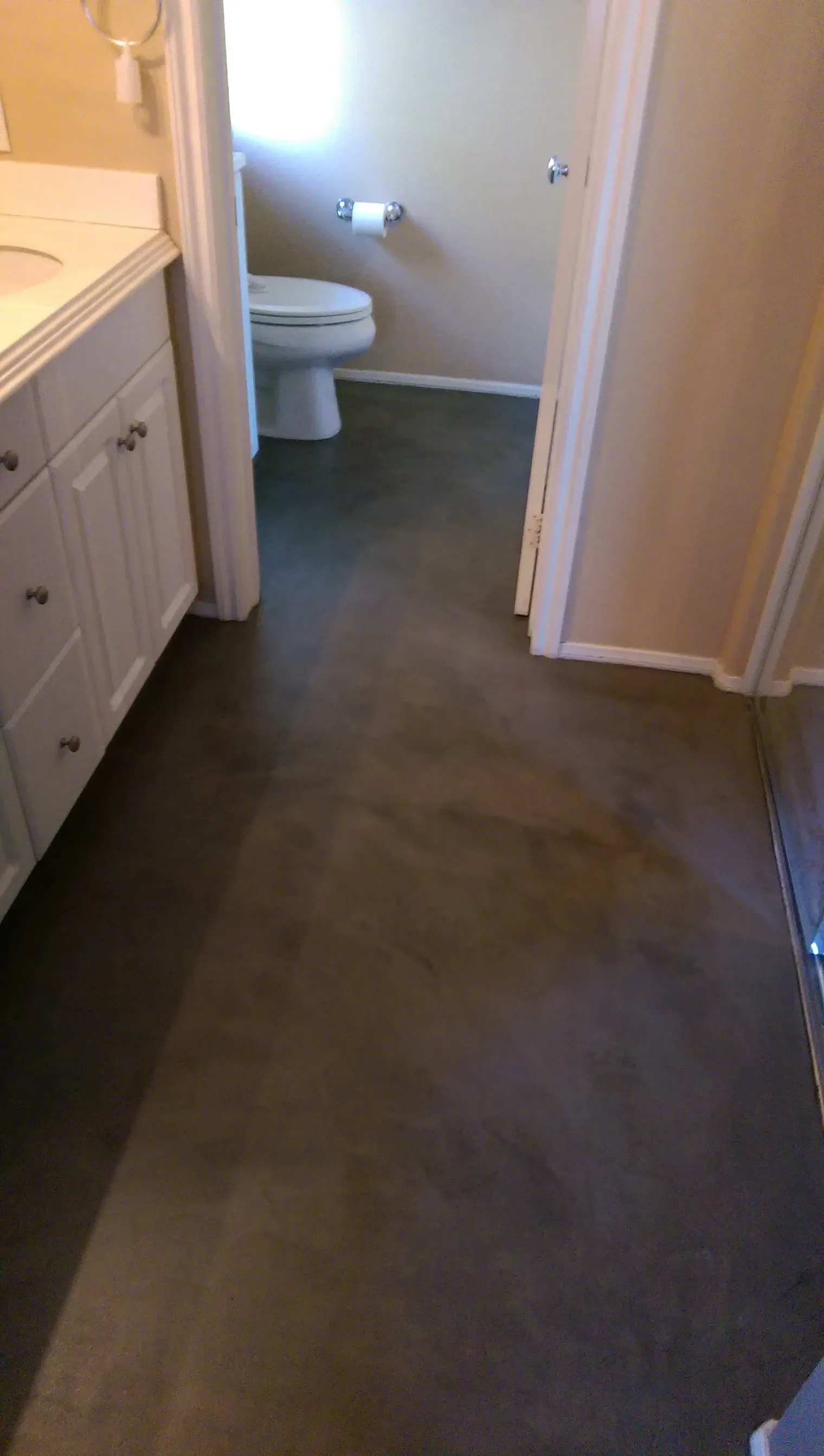 A bathroom with a toilet , sink , and door.