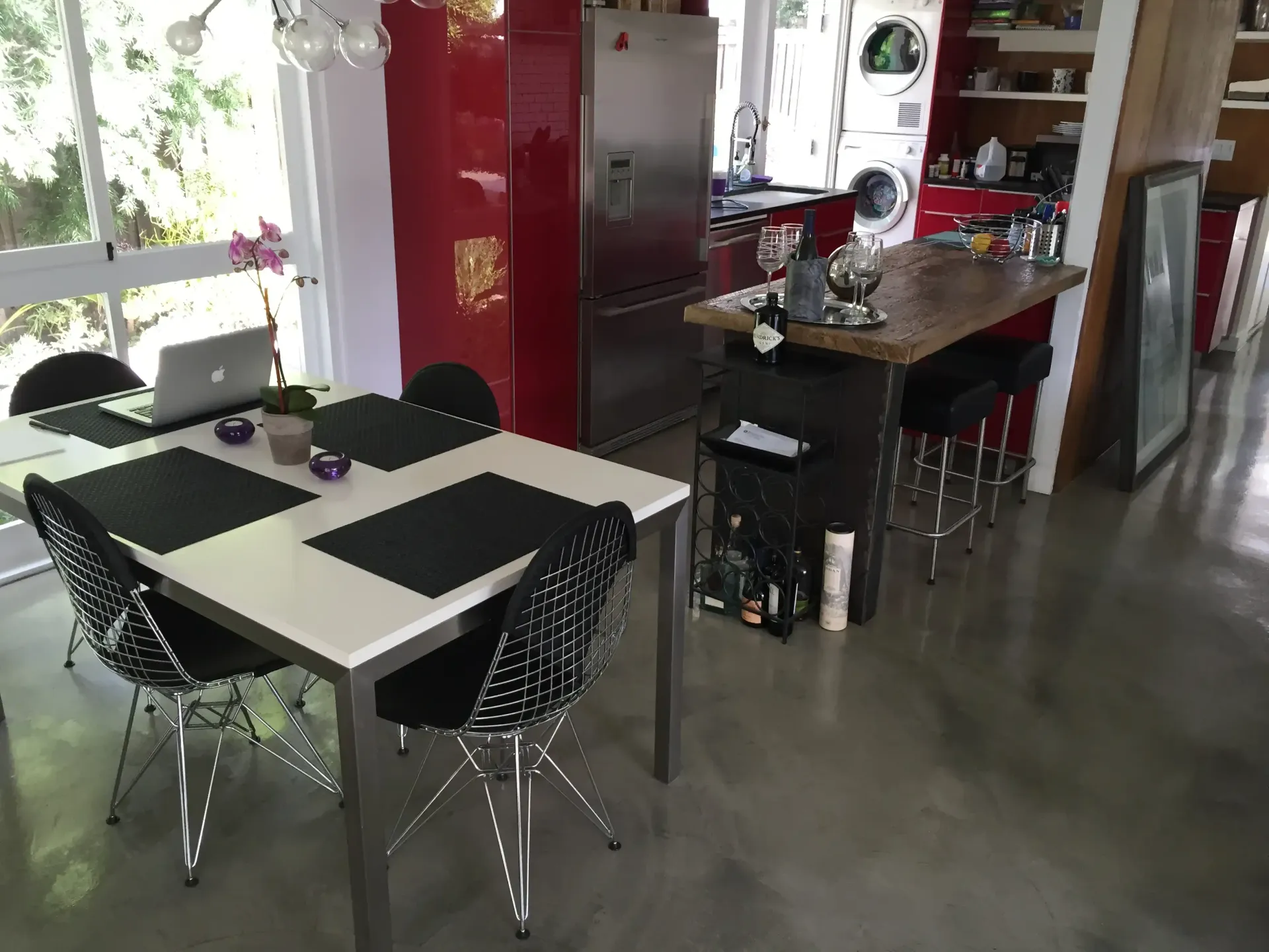 A kitchen with a table and chairs and a laptop on it