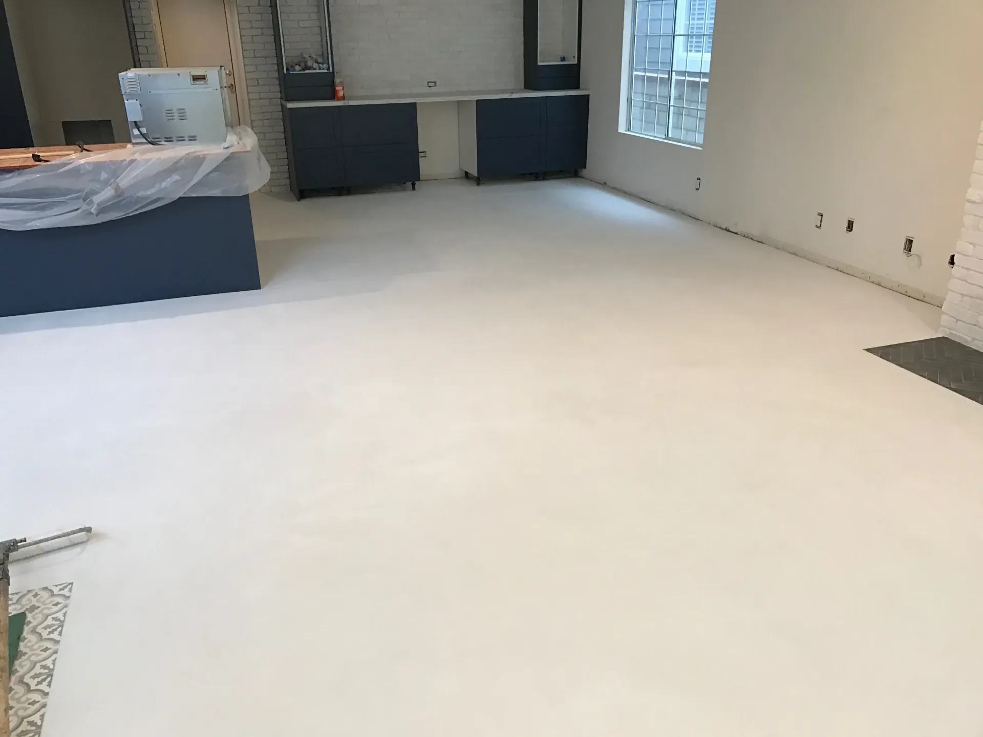 A large room with a white floor and blue cabinets