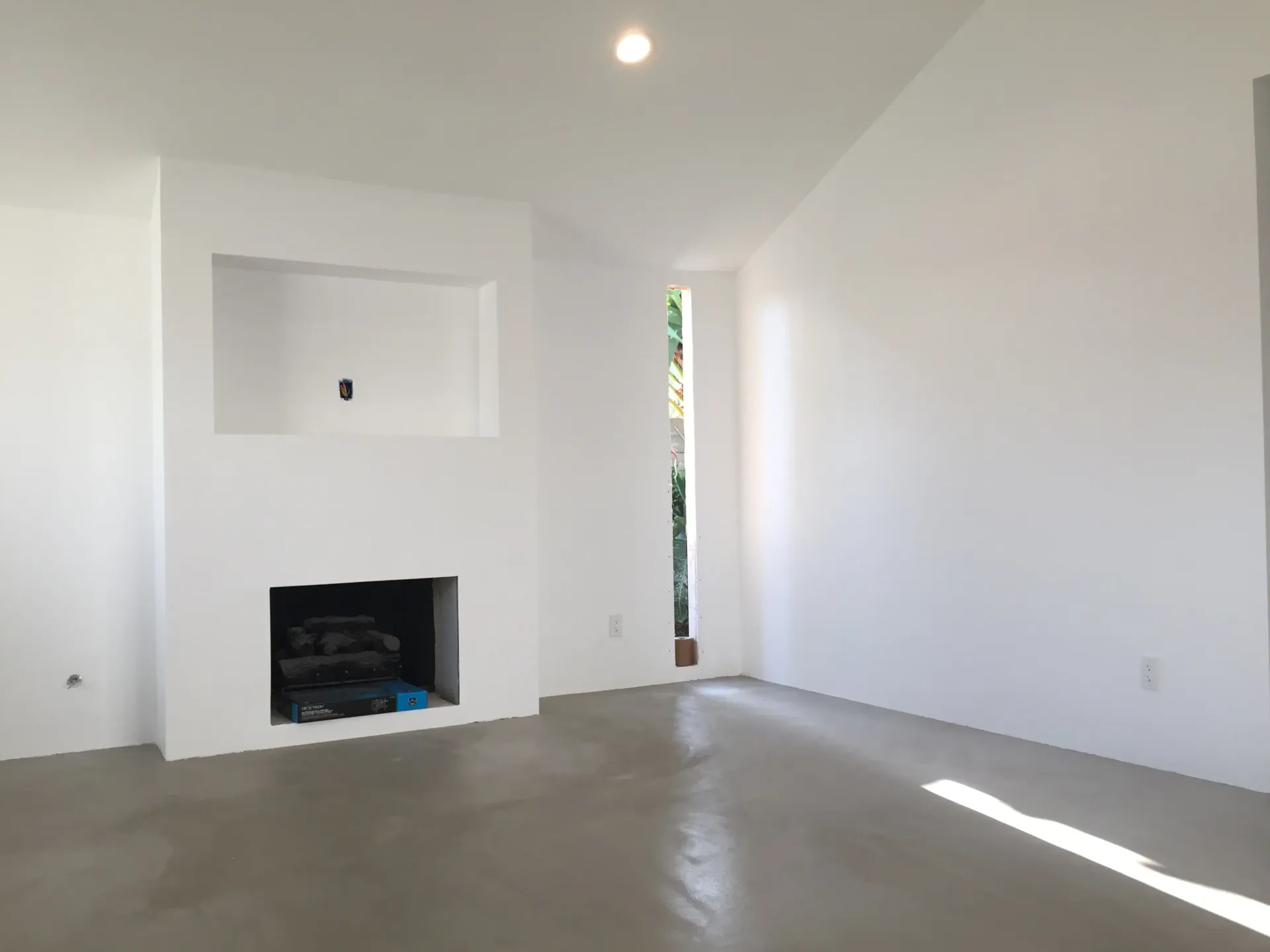 An empty living room with white walls and a fireplace