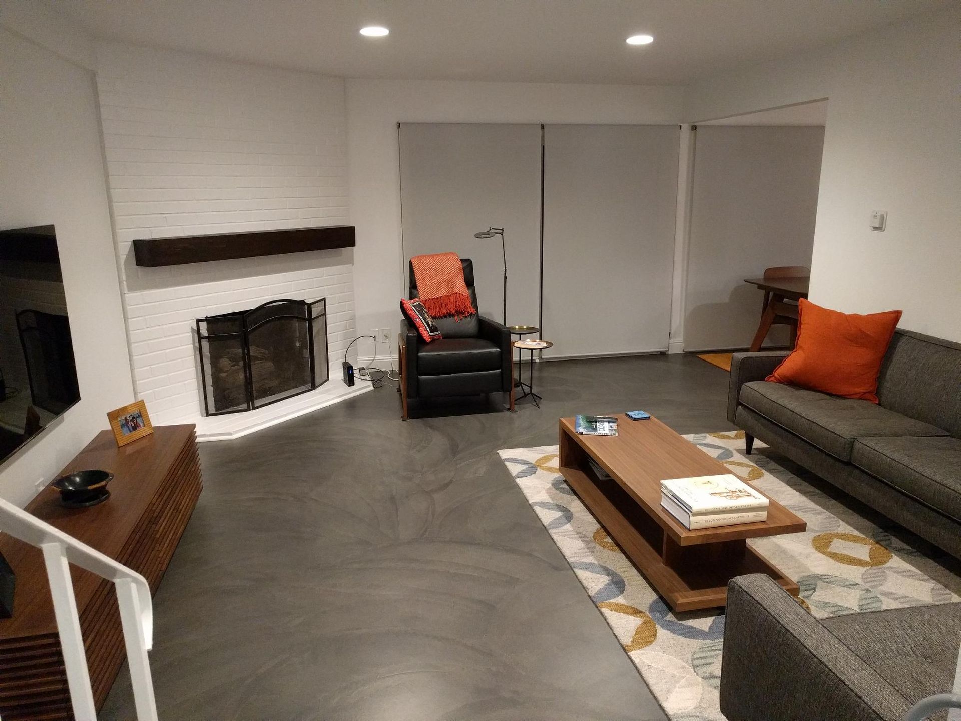 A living room with a couch , chair , coffee table and fireplace.