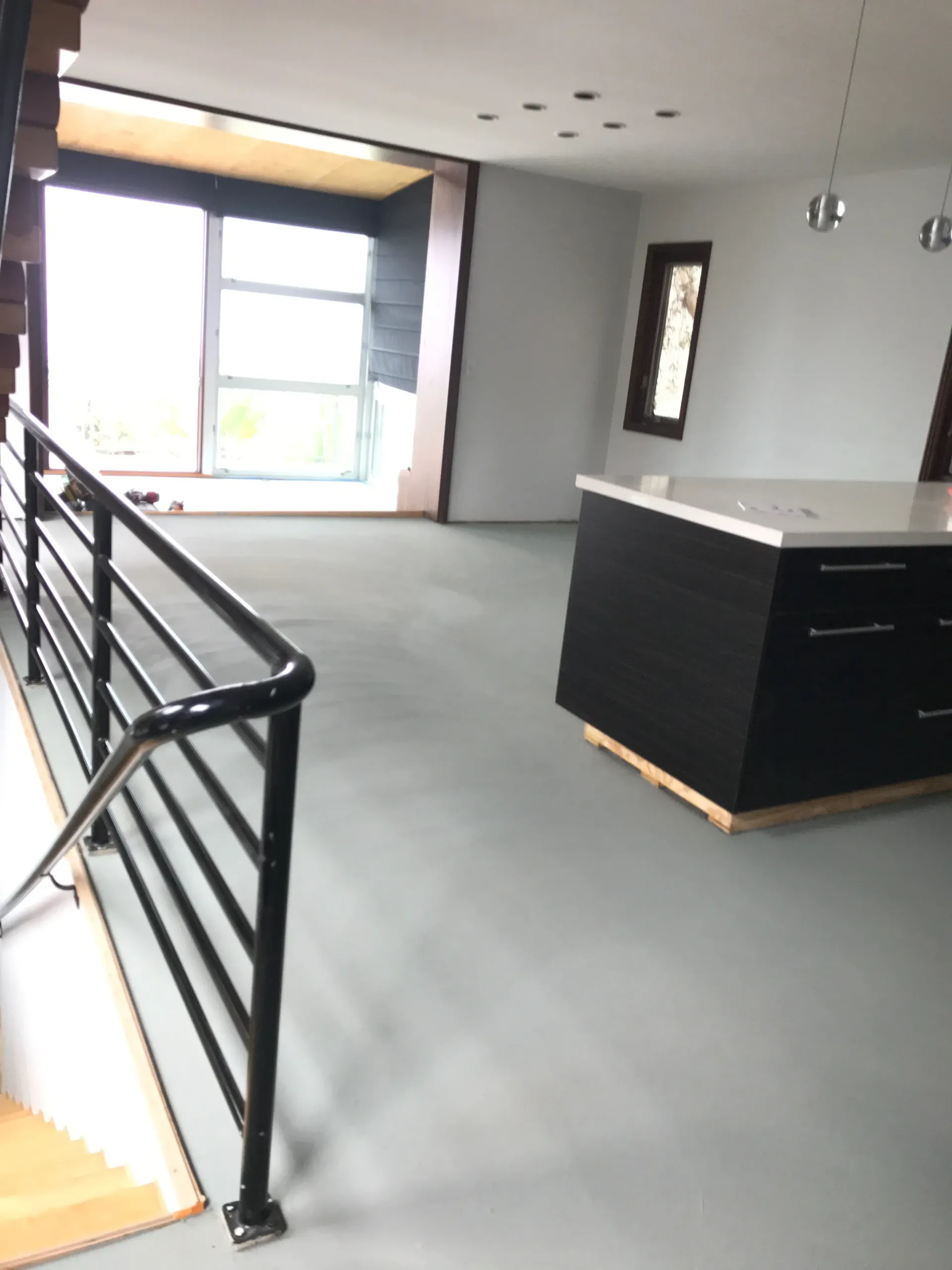 A kitchen with a black island and a black railing