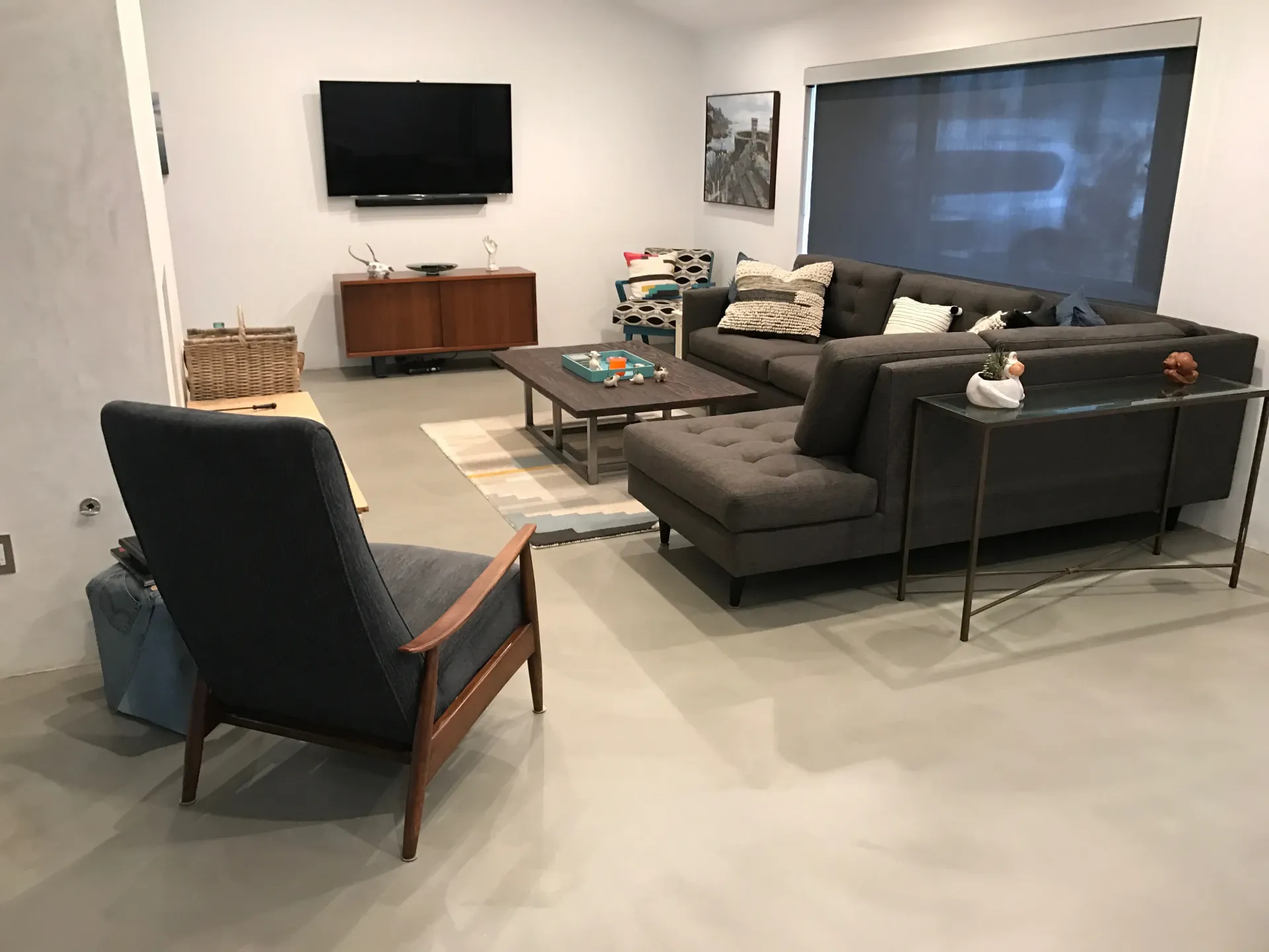 A living room with a couch , chair , coffee table and television.