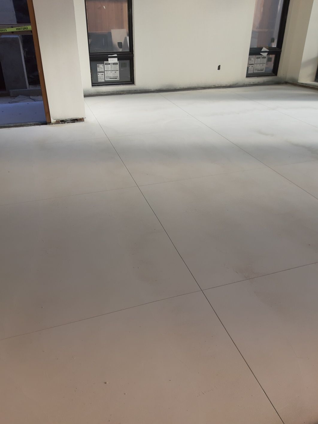 A large empty room with a white floor and a lot of windows.