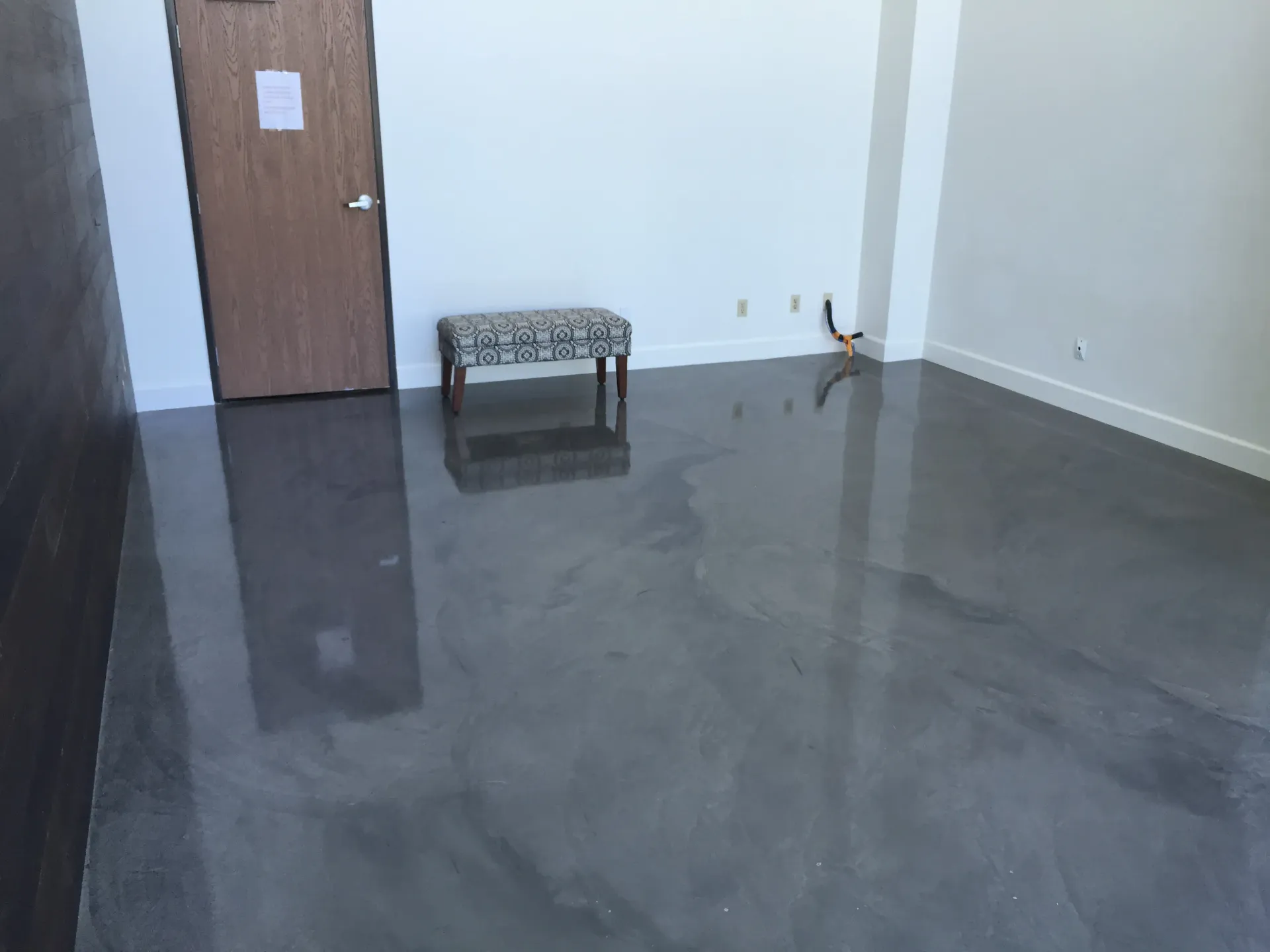 A room with a concrete floor and a bench in it