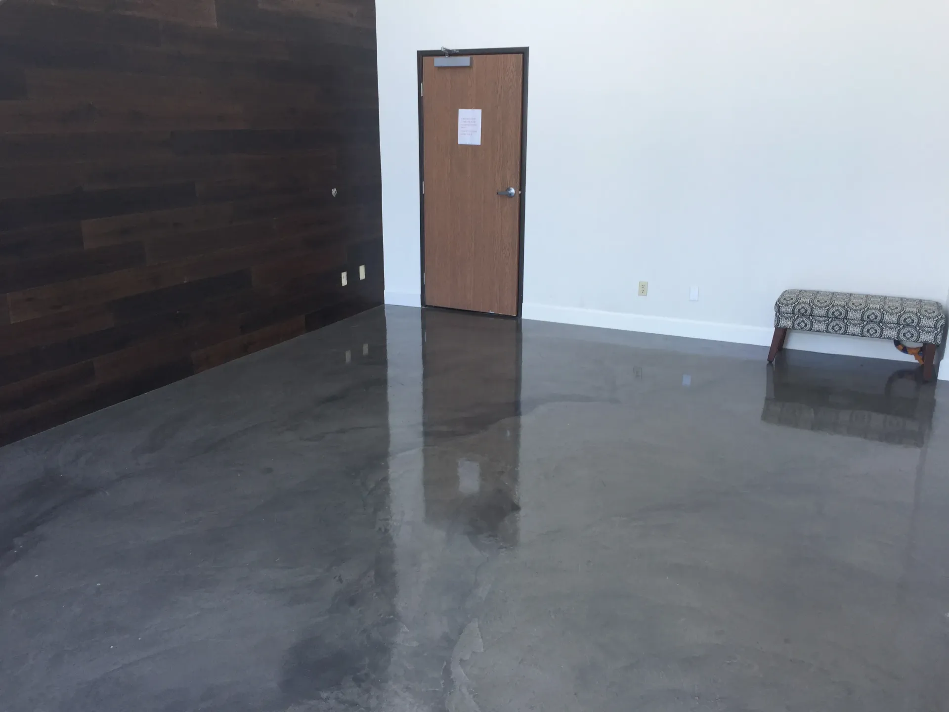 An empty room with a bench and a door