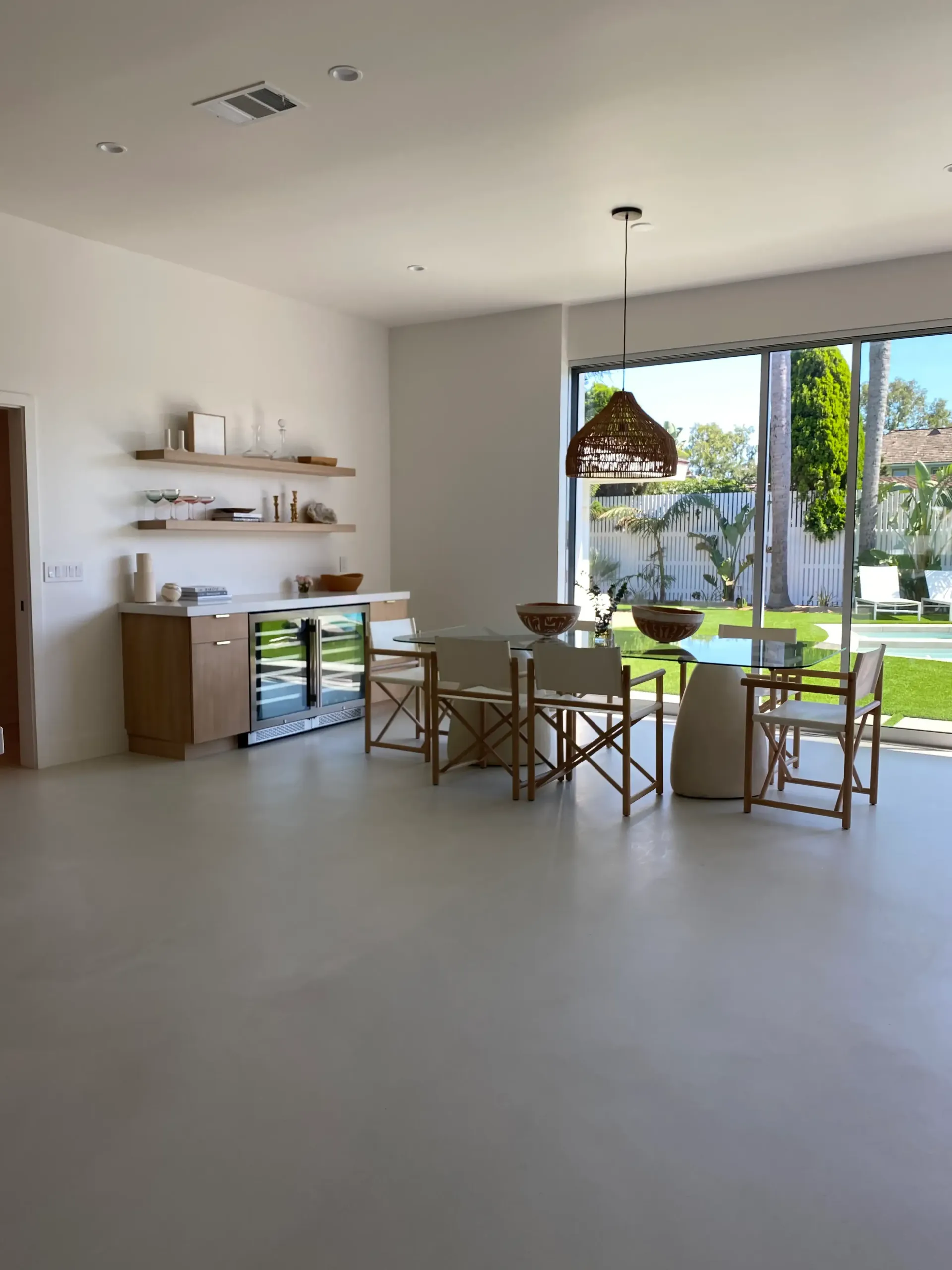 A dining room with a table and chairs and a large window.