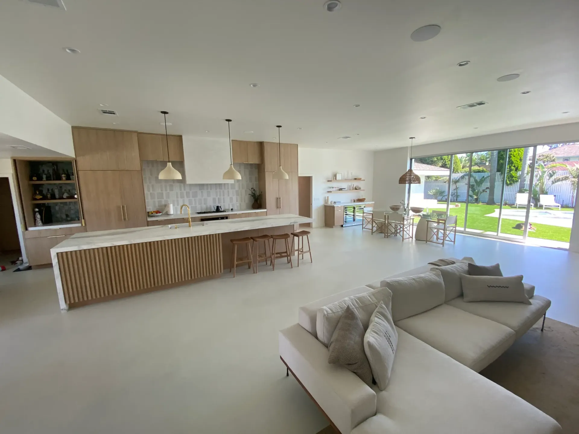 A living room with a couch and a kitchen in the background.