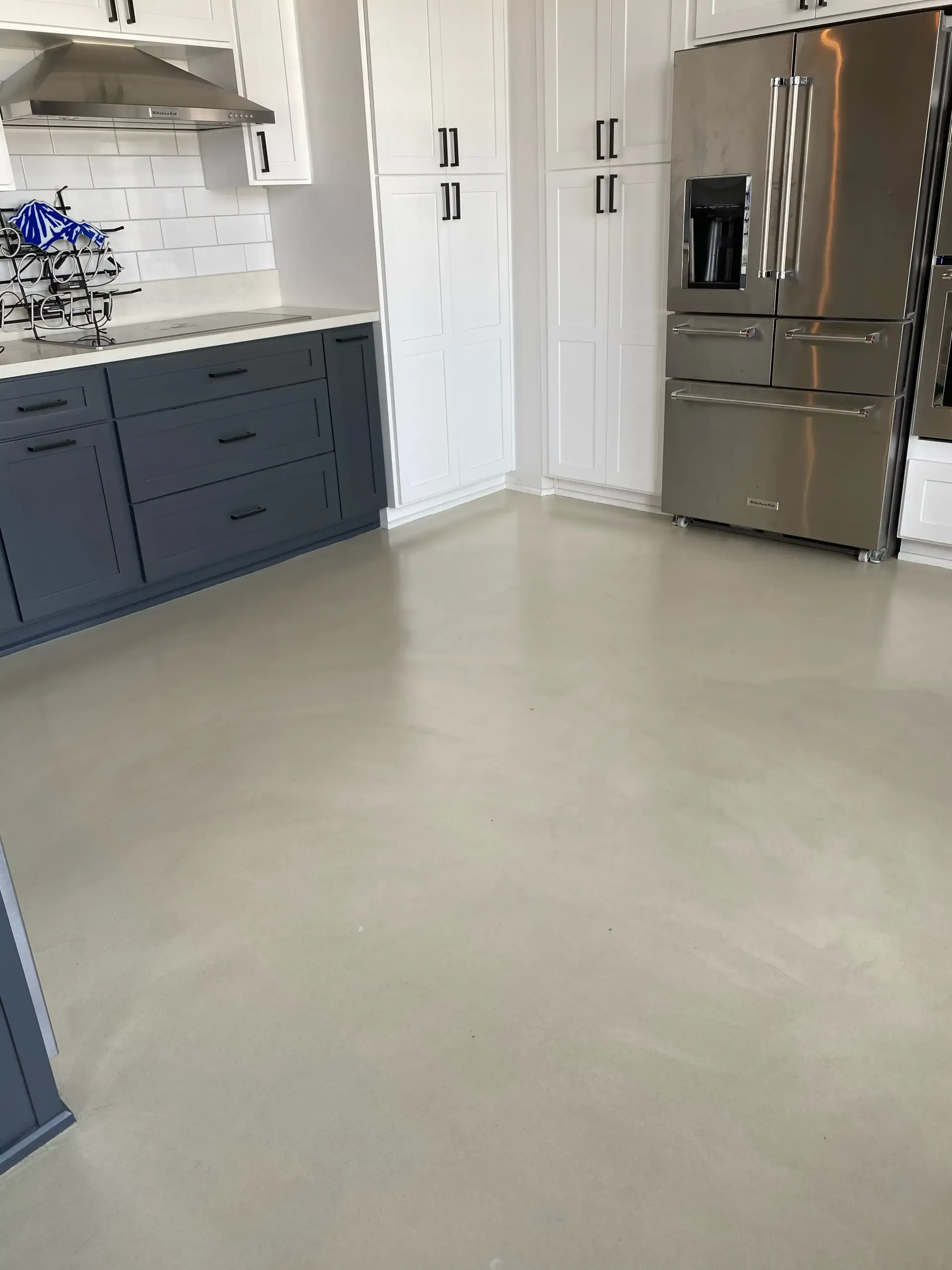 A kitchen with stainless steel appliances and blue cabinets.