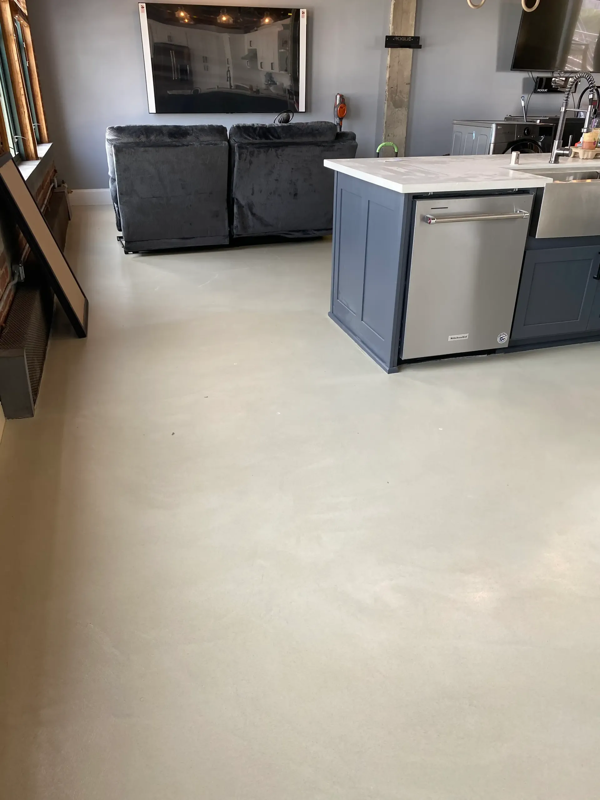 A living room with a couch and a television on the wall.