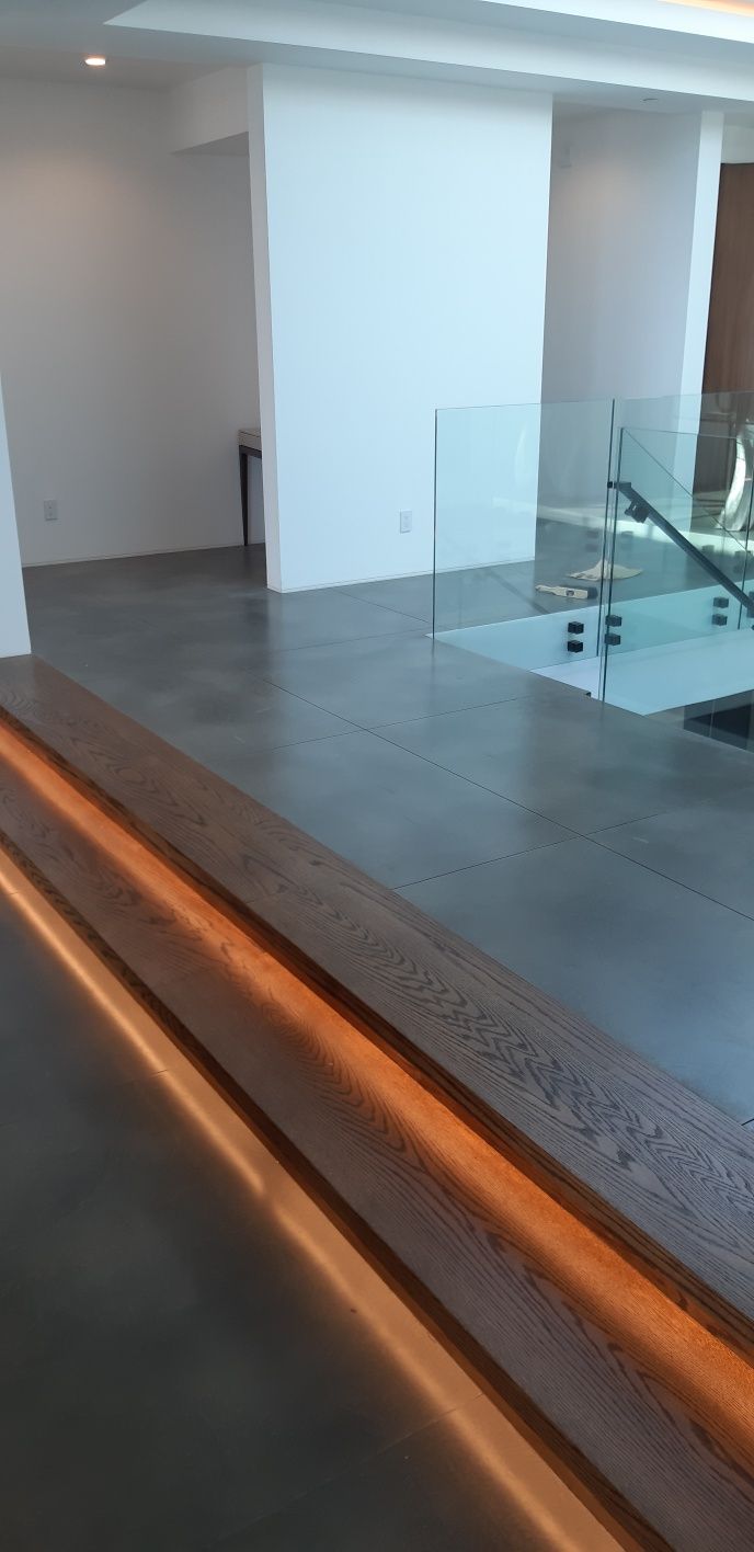A staircase with a wooden railing and a glass railing in a room.