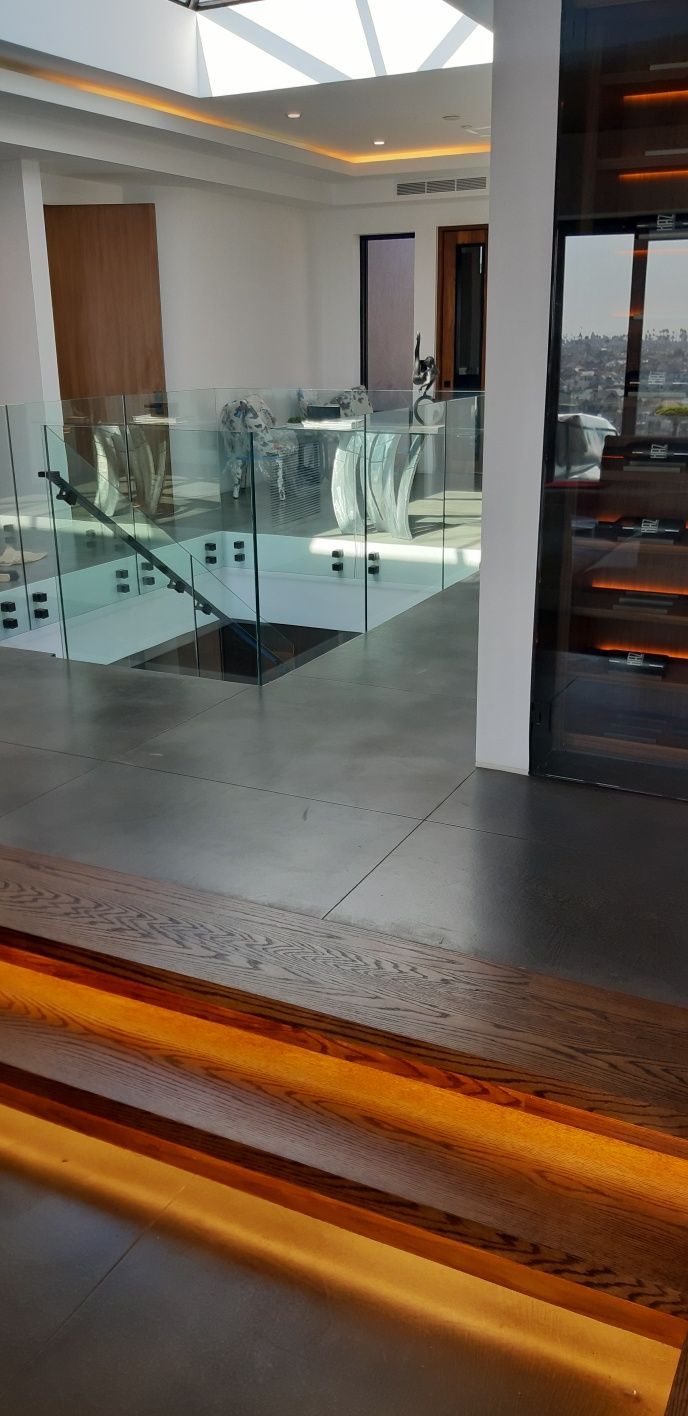 There is a staircase in the middle of the room with a glass railing.