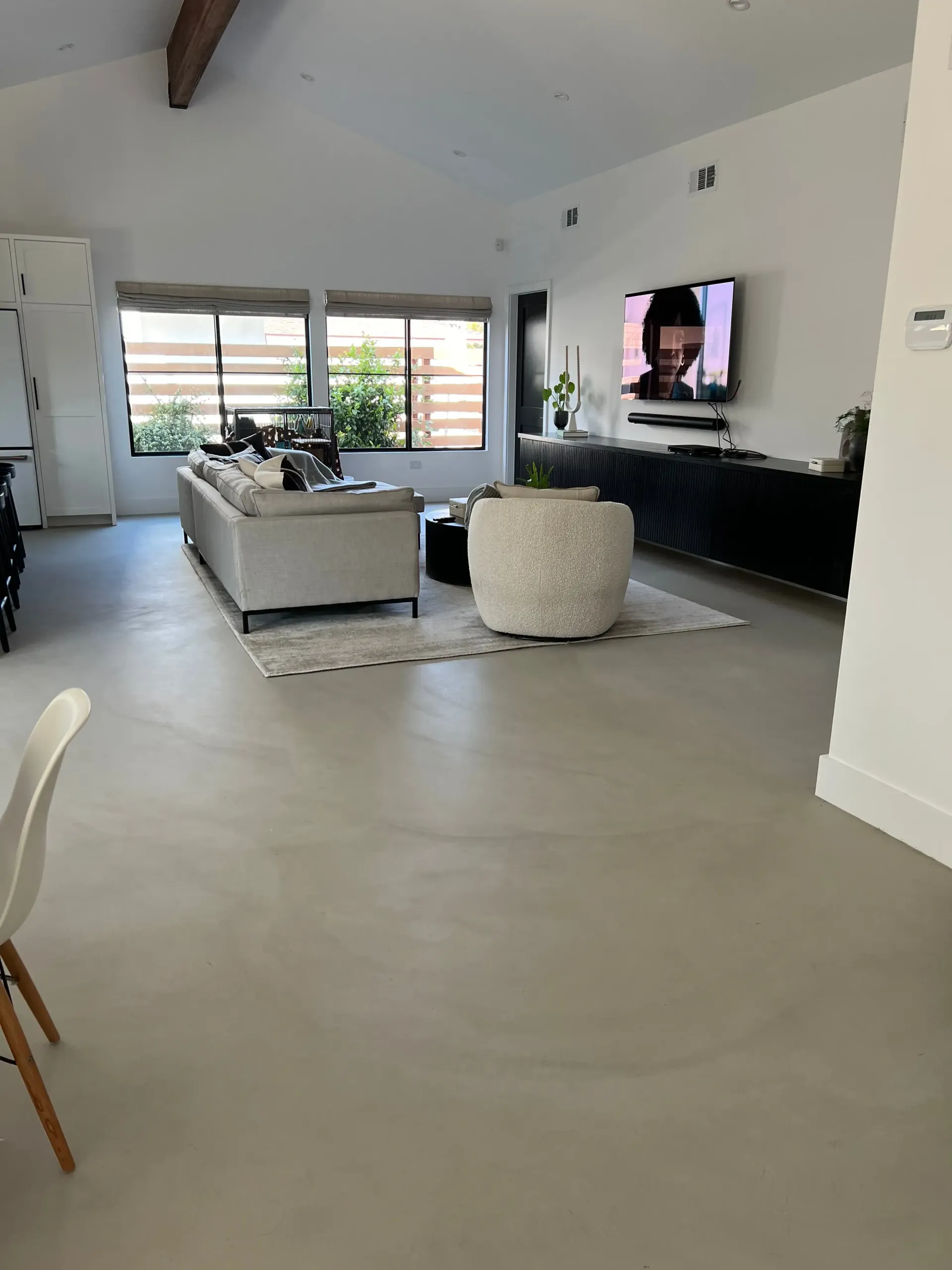 A living room with a couch and a television on the wall.