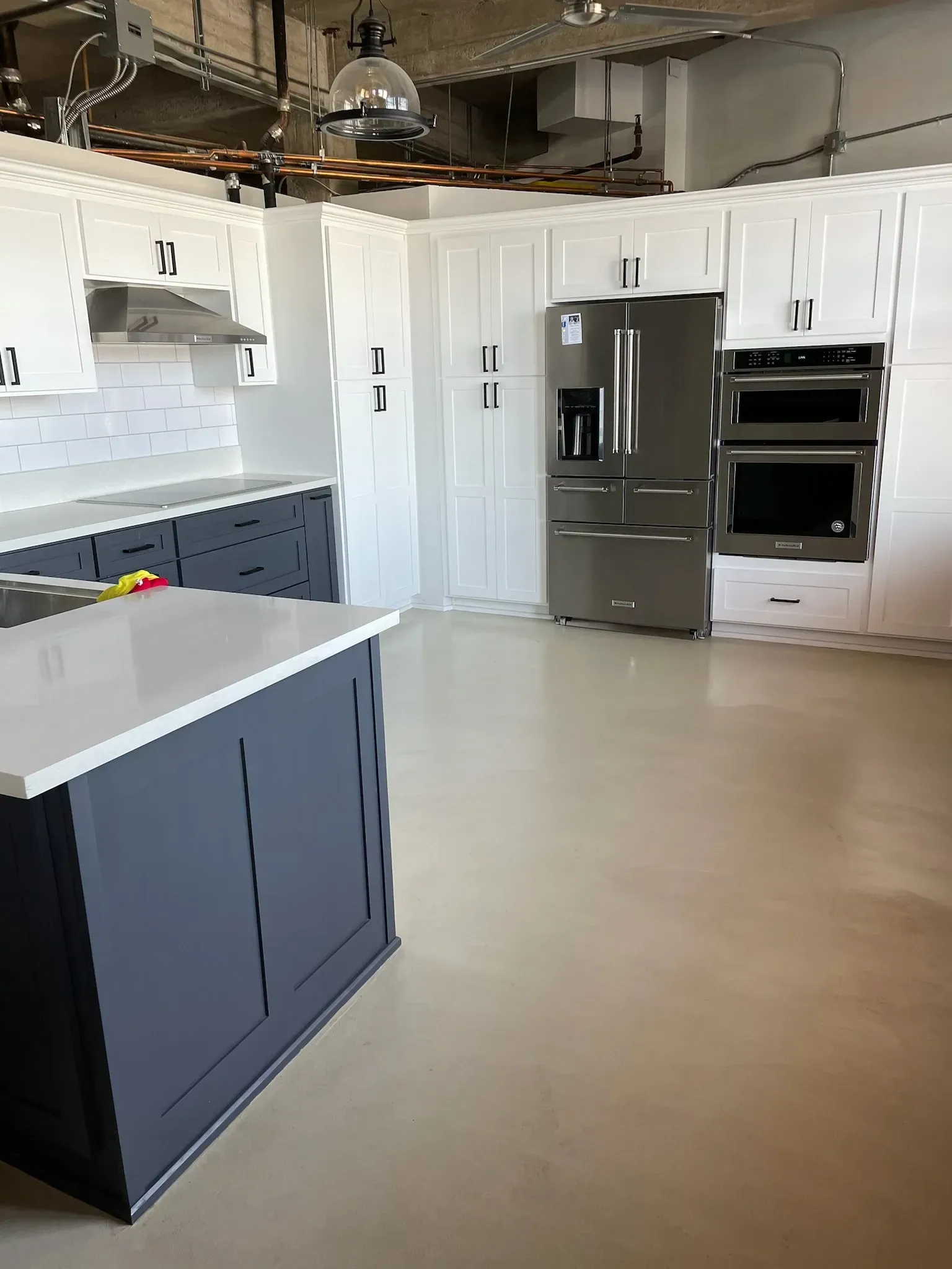 A large kitchen with stainless steel appliances and white cabinets.