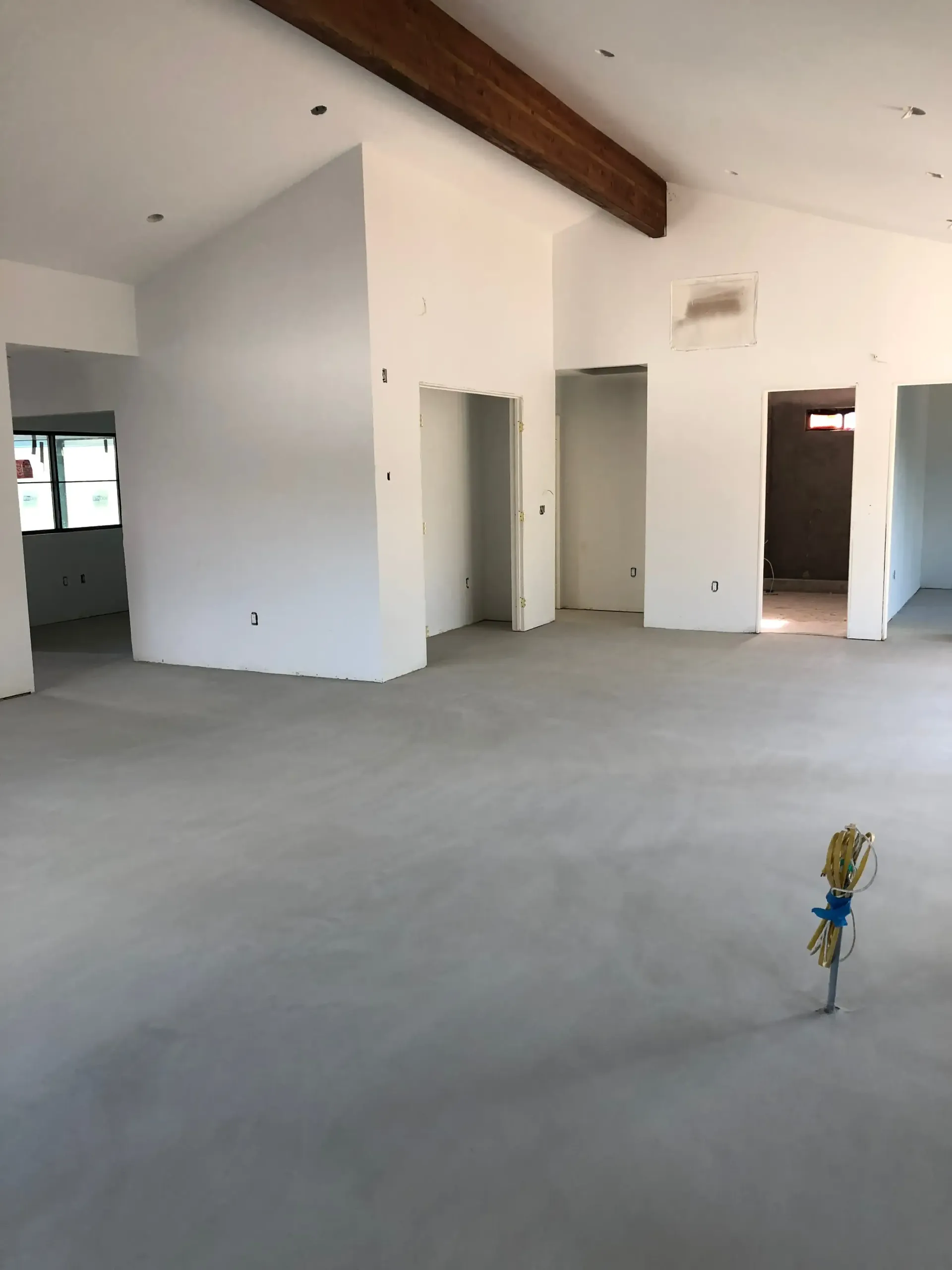 A large empty room with white walls and a concrete floor