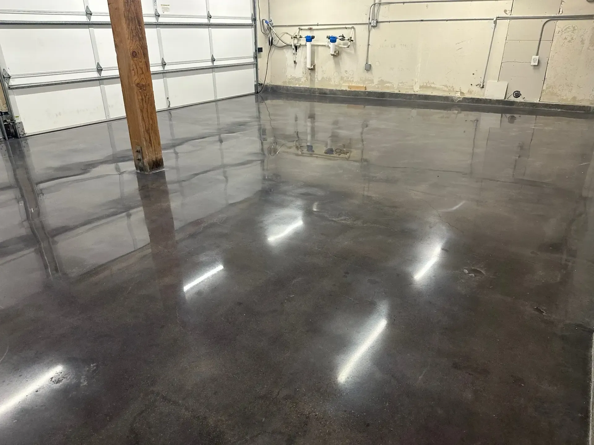 A garage with a shiny concrete floor and a garage door.