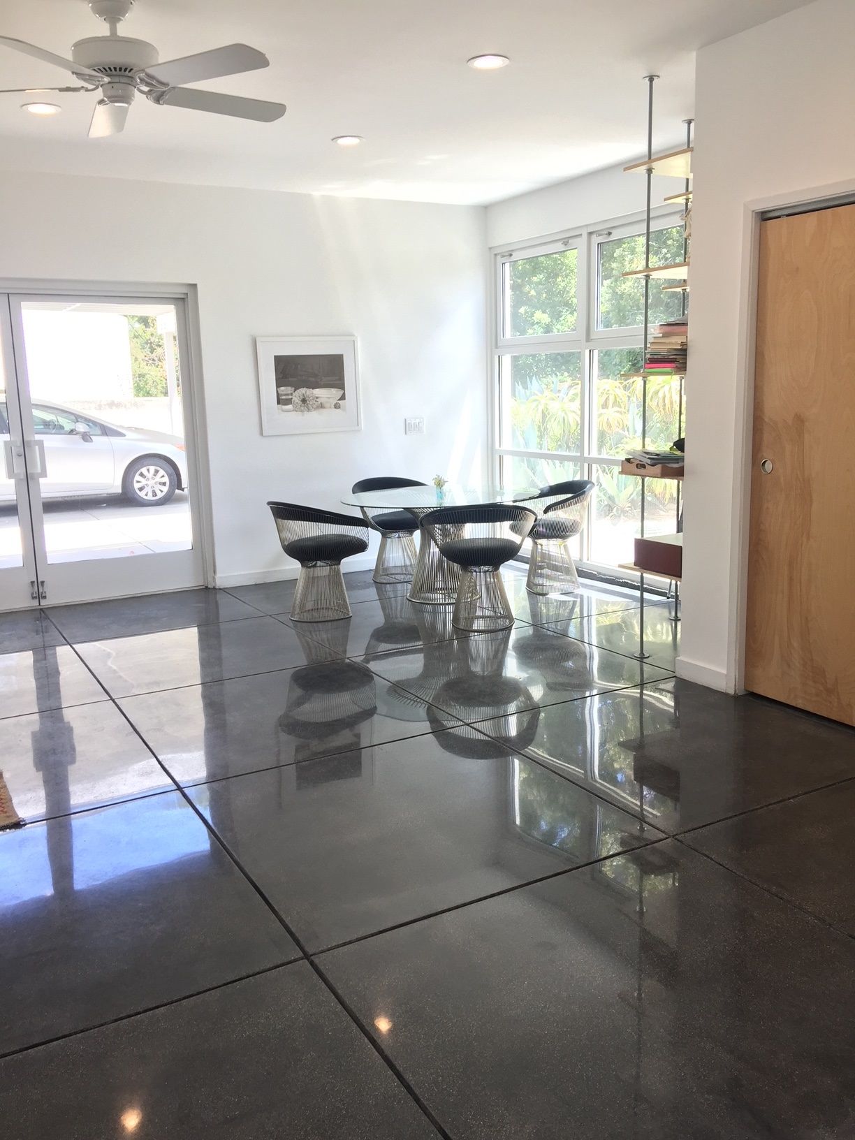 A room with a ceiling fan and a table and chairs in it.