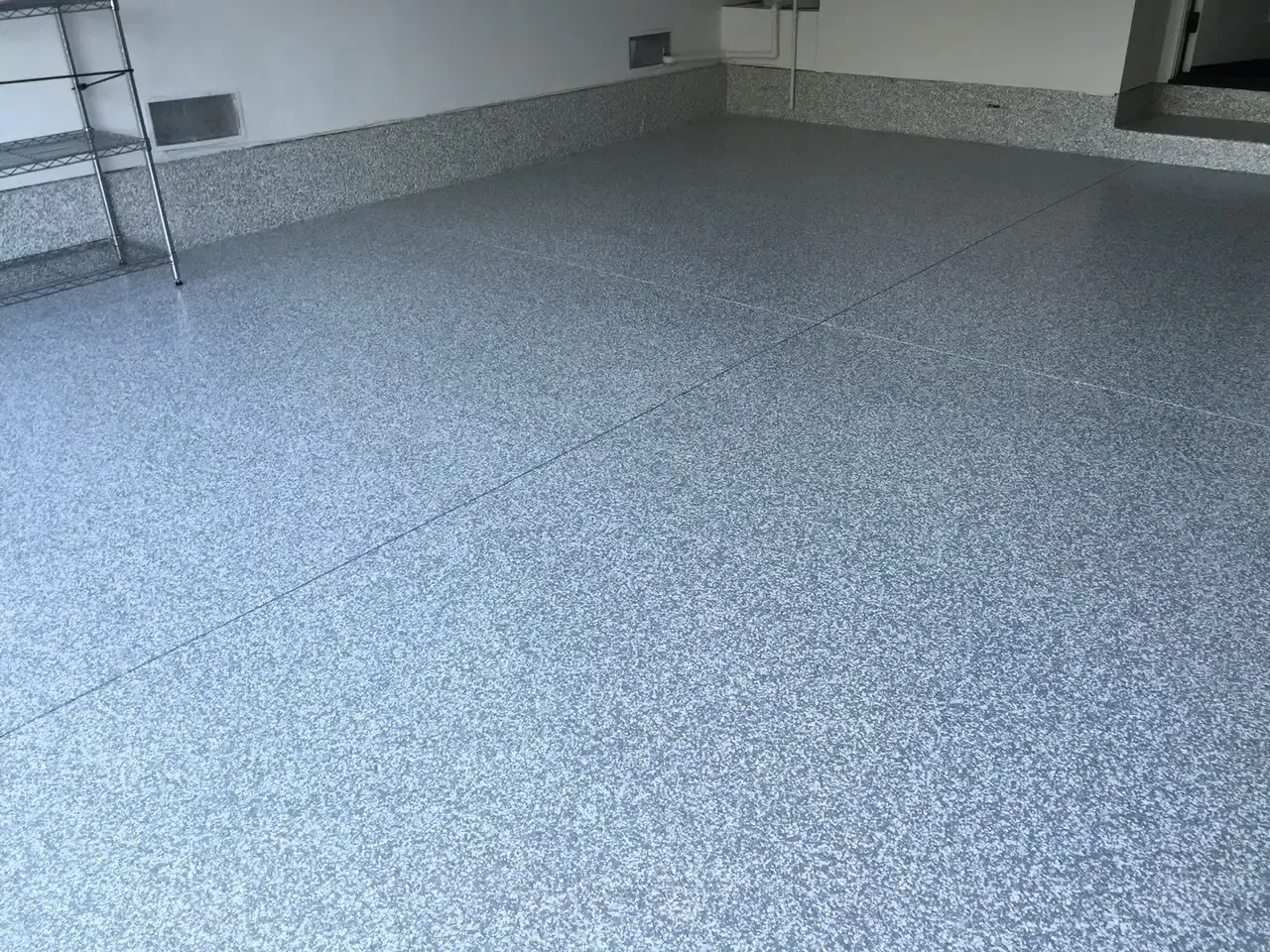 A garage with a ladder and a gray floor.