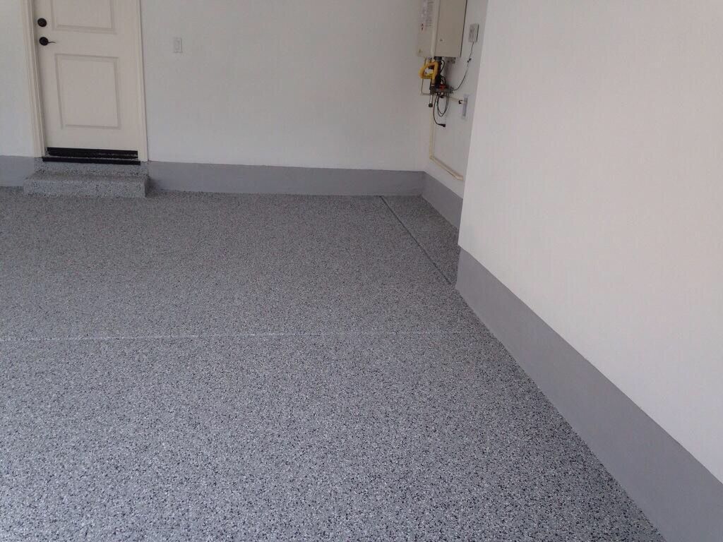 A garage with a gray floor and white walls.