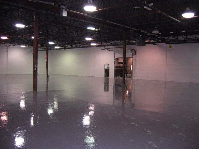 An empty warehouse with a shiny floor and white walls