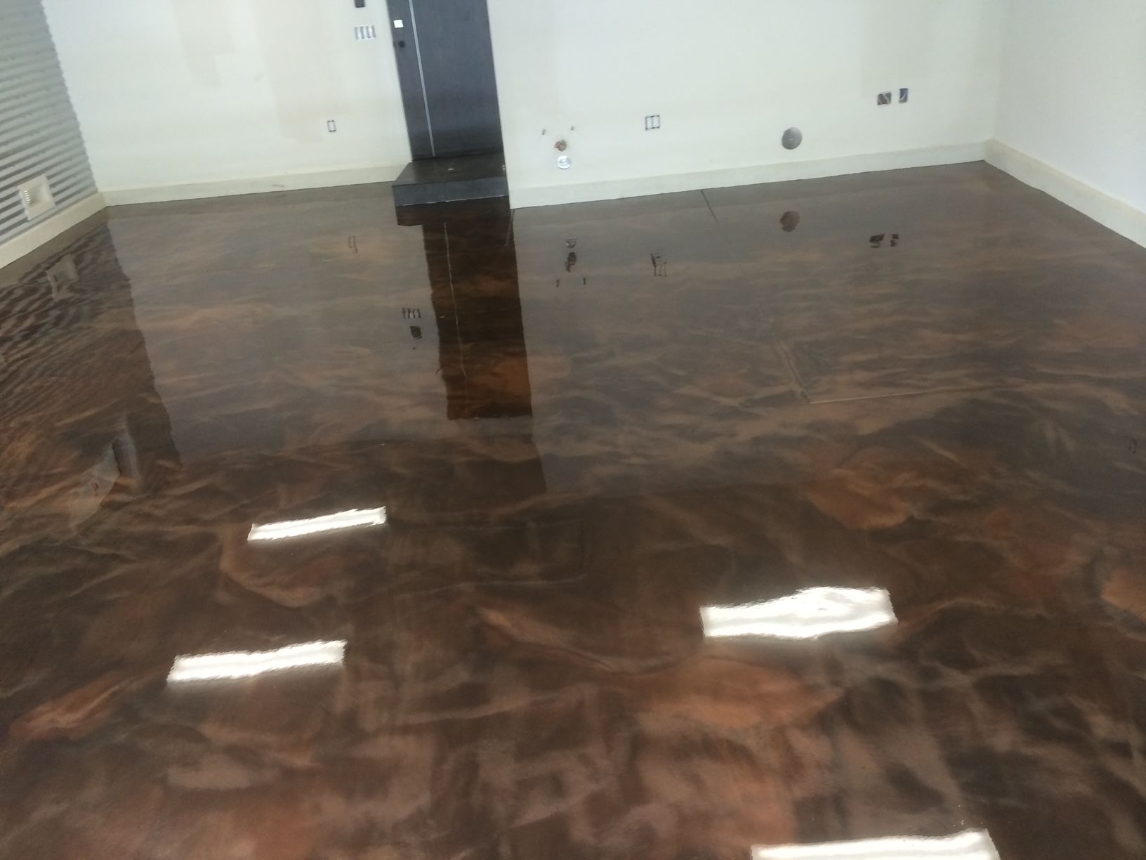 A room with a brown floor and white walls