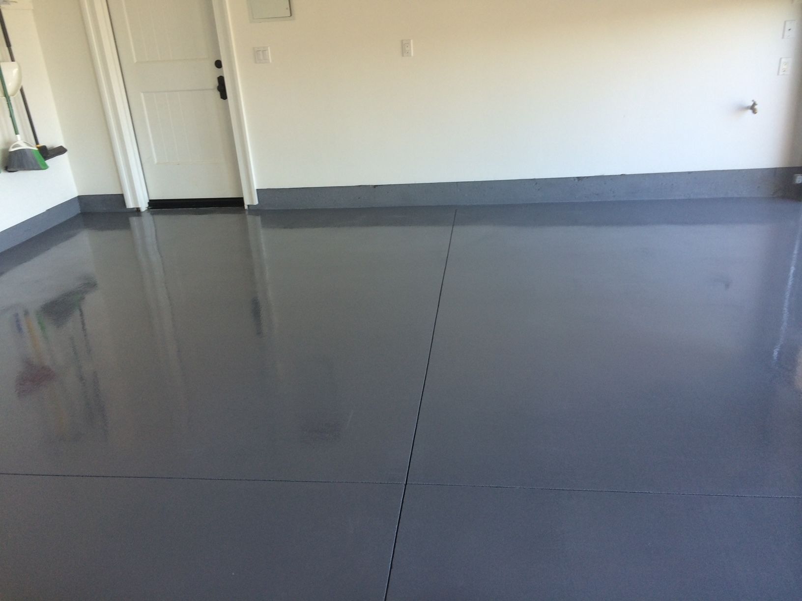 A garage with a gray floor and white walls