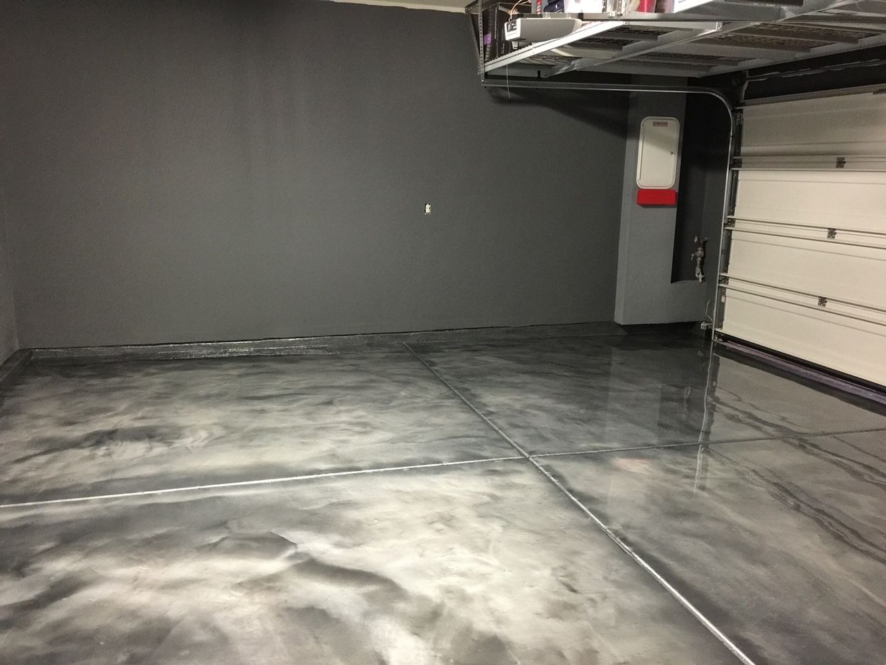 A garage with a metallic floor and a garage door.