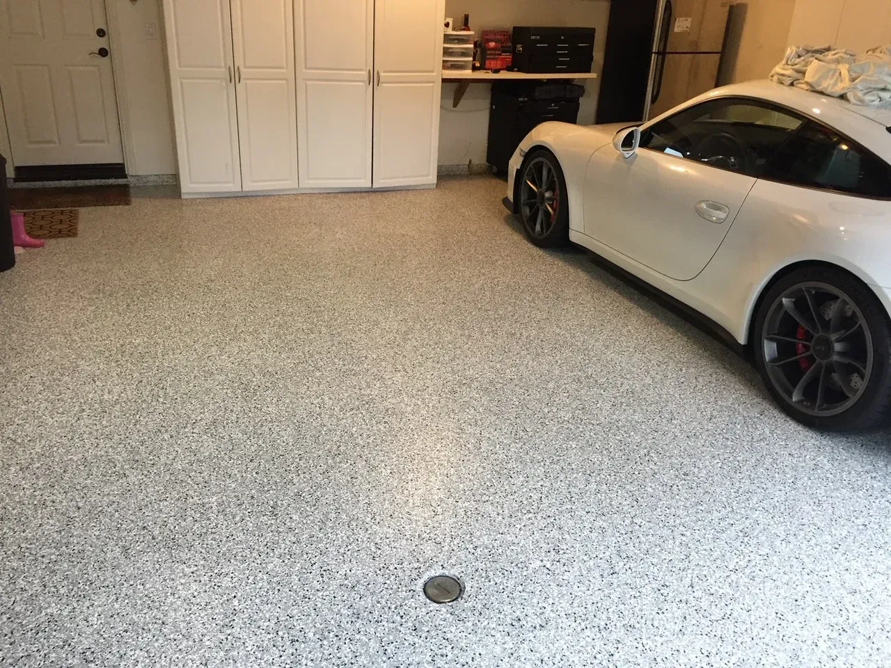 A white sports car is parked in a garage.