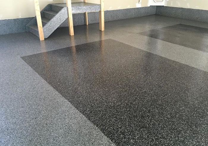 A garage with a staircase and a concrete floor.