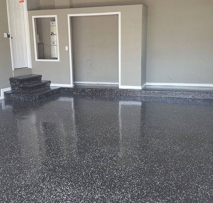 A garage with a black floor and stairs