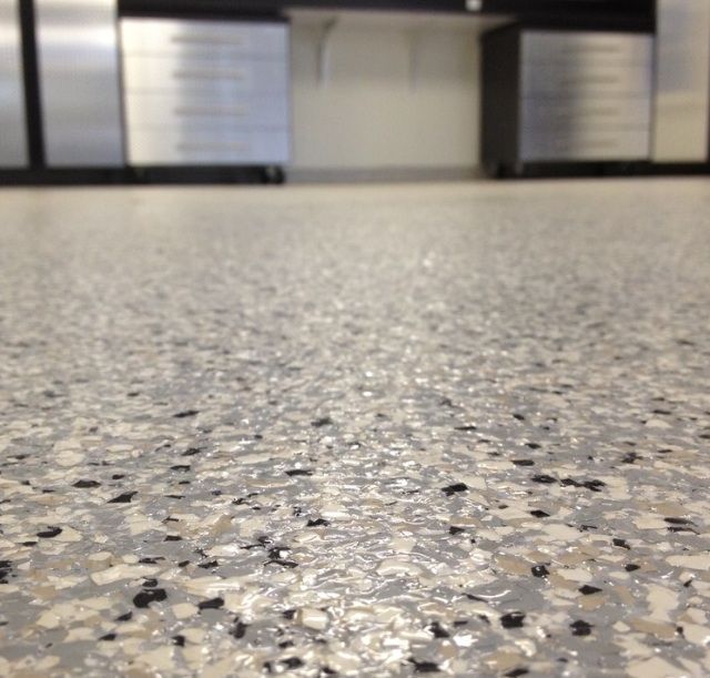 A close up of a gray floor with black spots