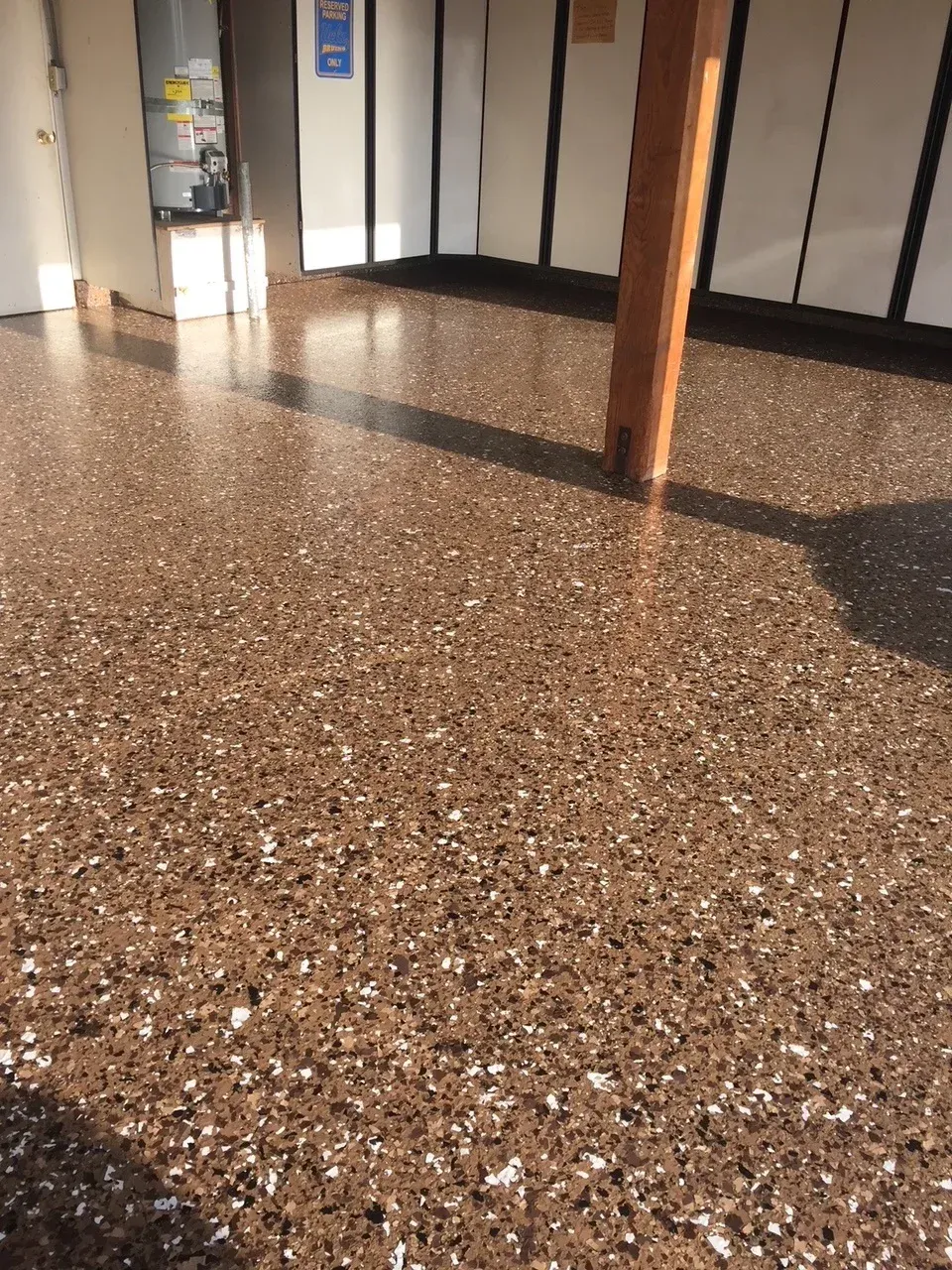 A room with a brown floor and a wooden post