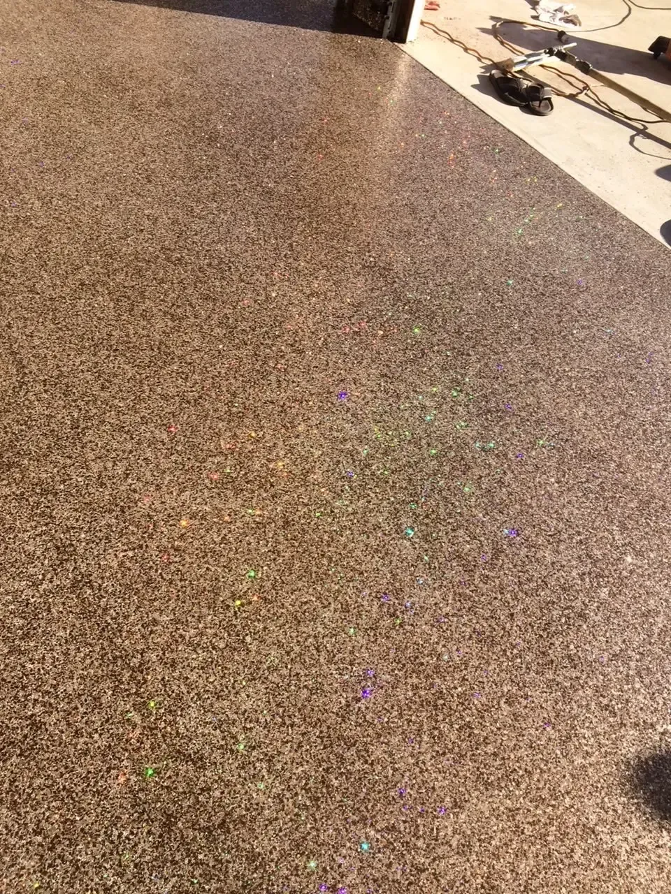 A close up of a concrete floor with a lot of small stones on it.