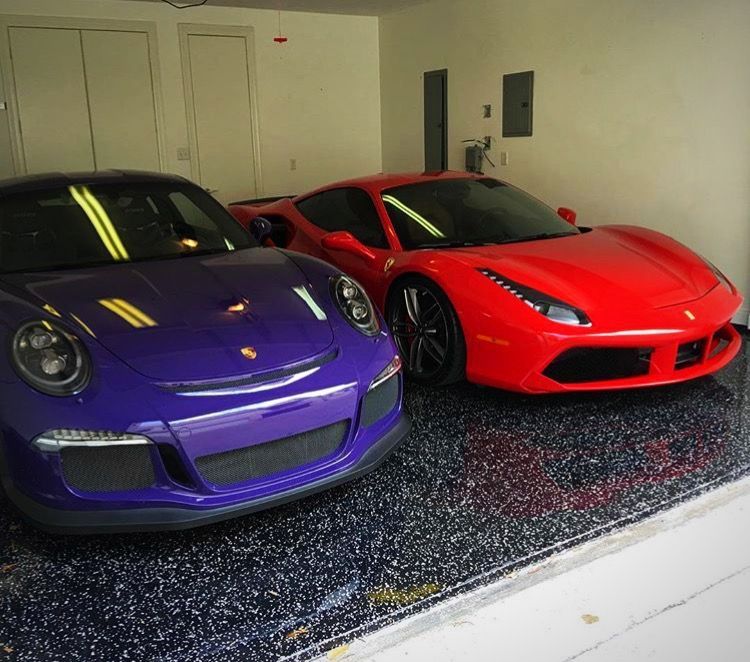 A purple car and a red car are parked in a garage