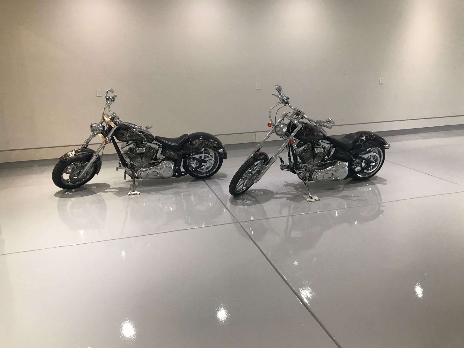 Two motorcycles are parked next to each other in a garage.