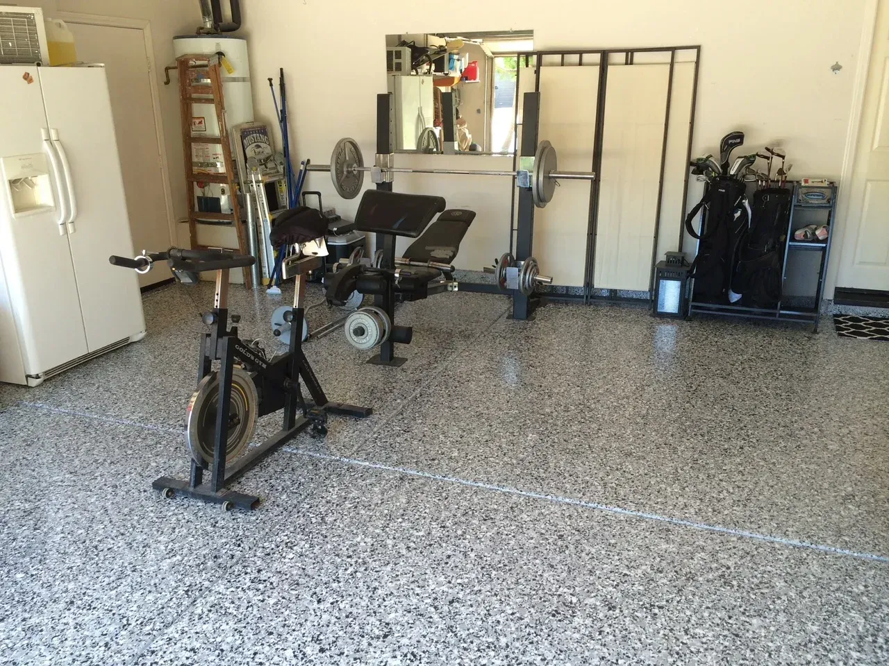 A spinning bike is sitting in the middle of a garage