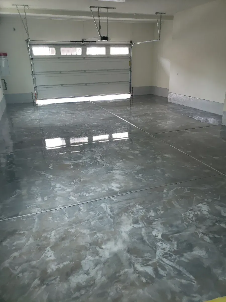 A garage with a metallic floor and a garage door.