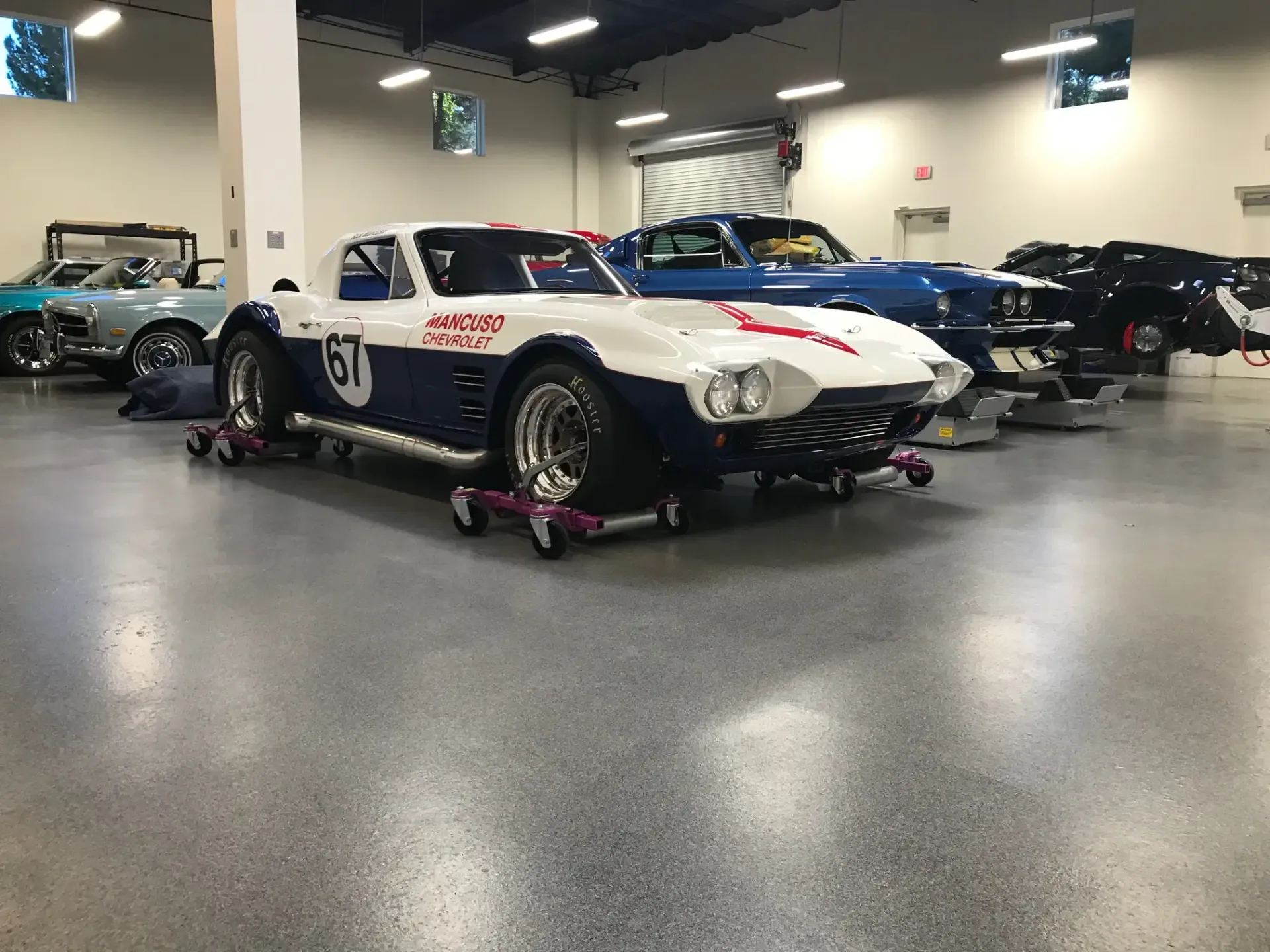 A blue and white race car is parked in a garage.