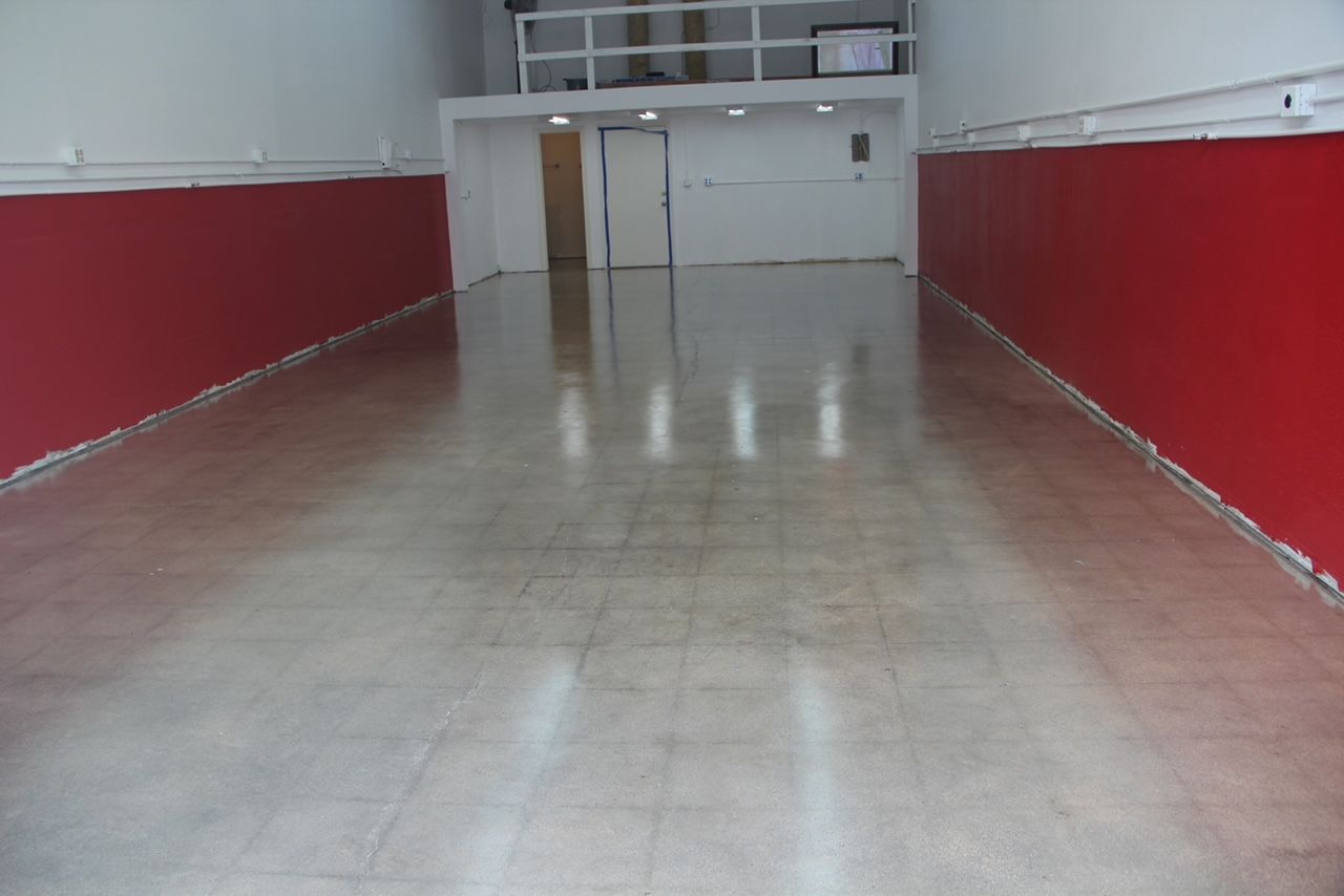 An empty room with red walls and a white floor