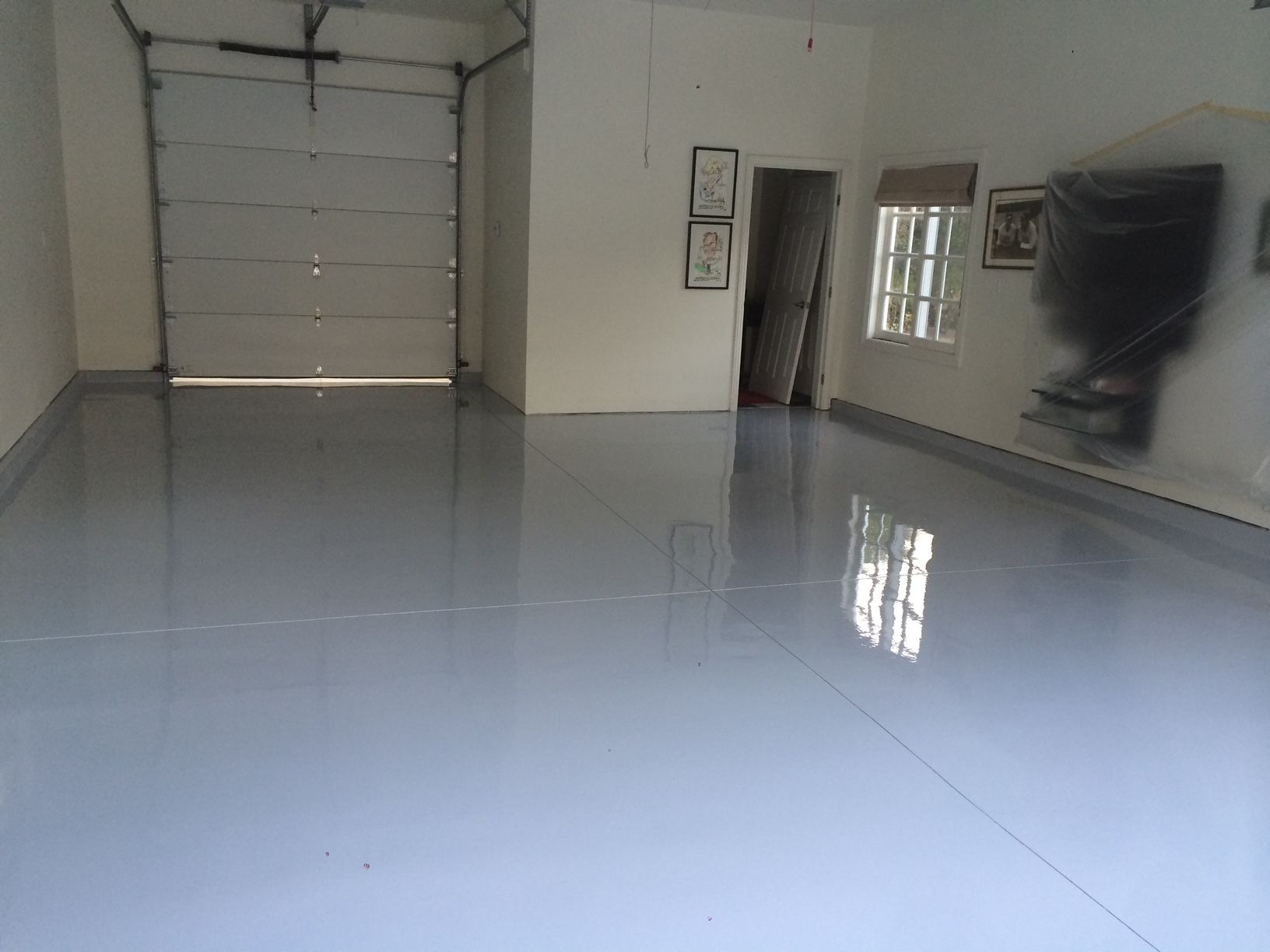 A garage with a white door and a blue floor