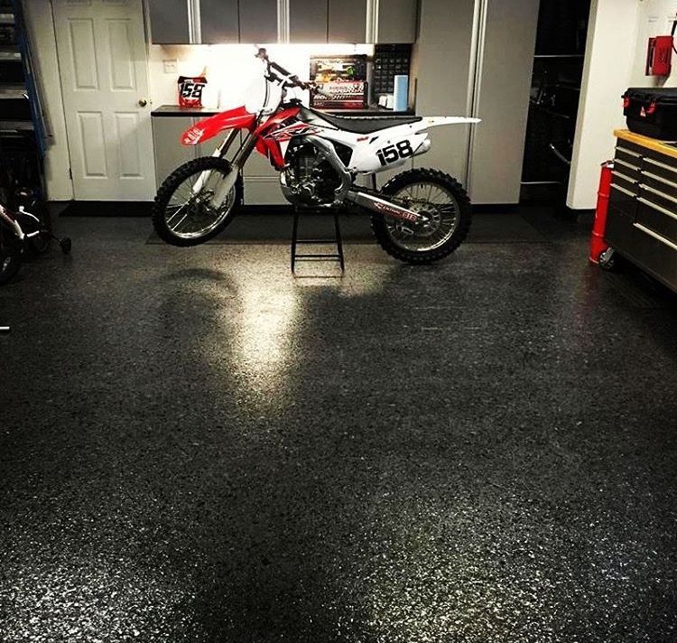 A dirt bike with the number 168 on the front is parked in a garage