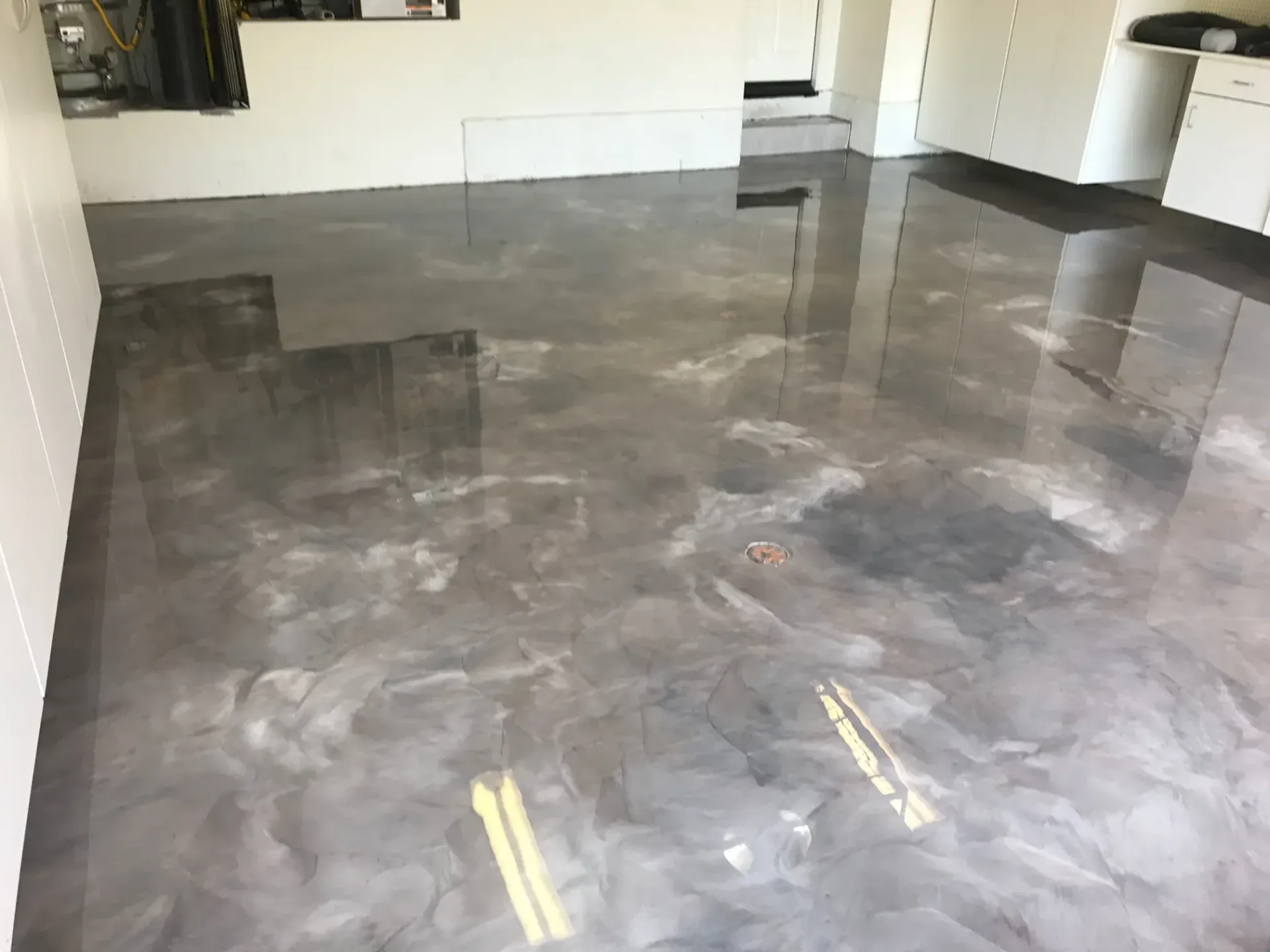 A shiny metallic floor in a room with white walls.