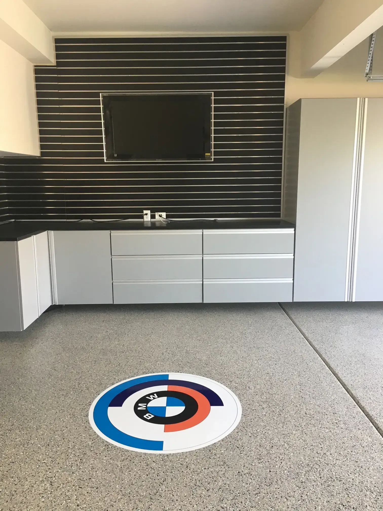 There is a bmw logo on the floor of the garage.