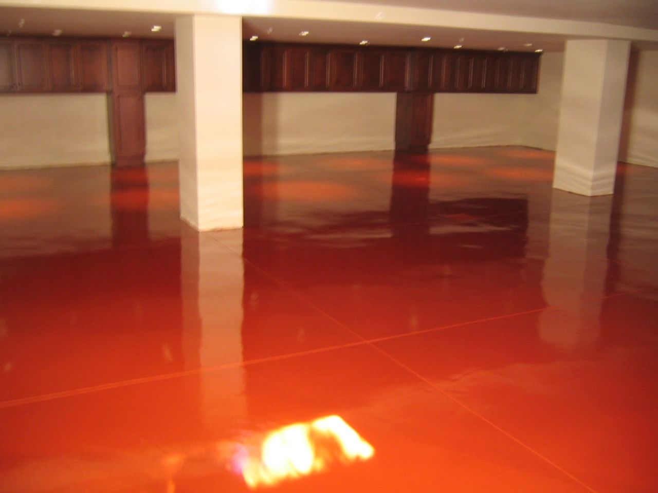 A room with a red floor and white pillars