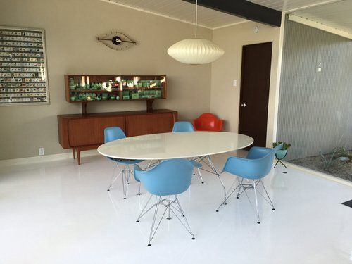 A dining room with a round table and blue chairs