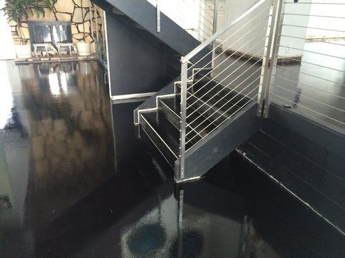 A black staircase with a stainless steel railing