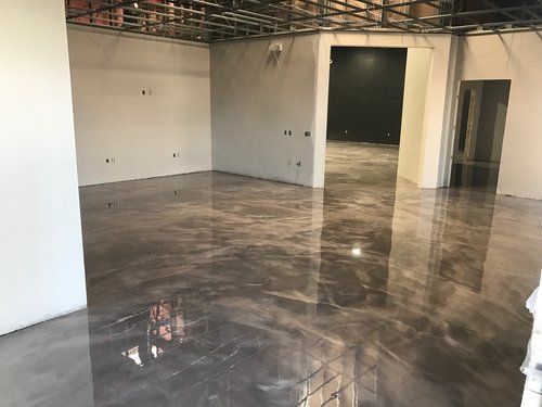 A large room with a shiny metallic floor and white walls.