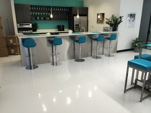 A kitchen with a white floor and blue stools.