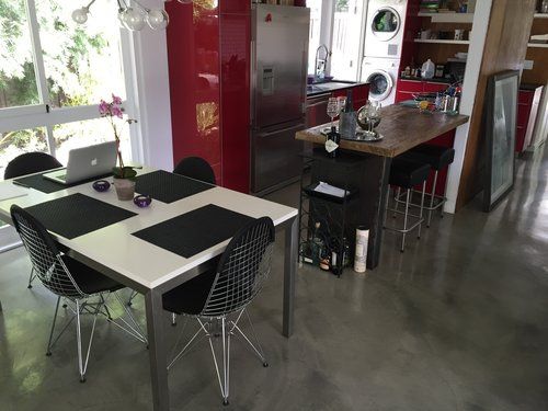 A kitchen with a table and chairs and a laptop on it