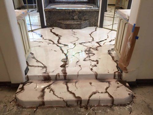 A bathroom with a marble floor and steps leading to a fireplace.
